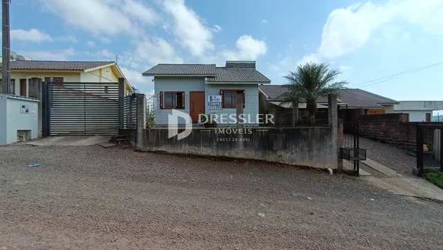 Fachada de uma residência com muro e portão de ferro.