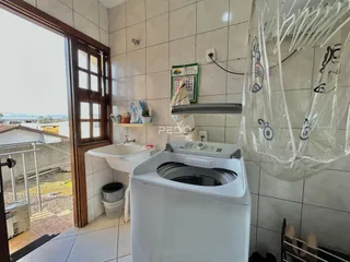 Imagem de um ambiente interno com azulejos e uma máquina de lavar roupa.