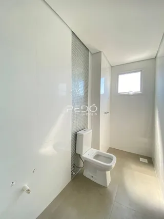 Foto de um banheiro interno com azulejos e vaso sanitário branco.