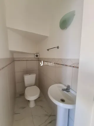 Foto de um banheiro com revestimento de azulejos brancos.
