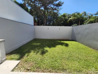 Um gramado verde cercado por paredes brancas é visível na propriedade.