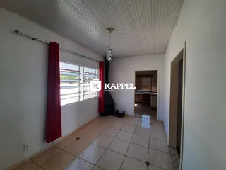 Sala de estar com piso de cerâmica e cortinas vermelhas.