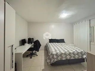 Quarto com cama e escrivaninha em um apartamento.