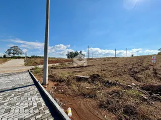Vista exterior de uma propriedade com terreno seco e caminho pavimentado.