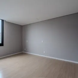 Interior de um cômodo com paredes cinzas e piso claro.
