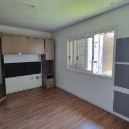 Foto de um ambiente interno com piso de madeira e janela.