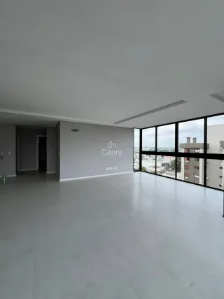 Foto de um espaço interno amplo com piso cinza e grandes janelas.