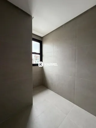 Hall de corredor com paredes claras e piso de cerâmica.