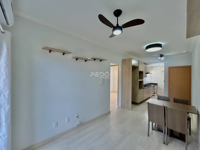 Ambiente interno de uma sala com piso de madeira clara e paredes brancas.