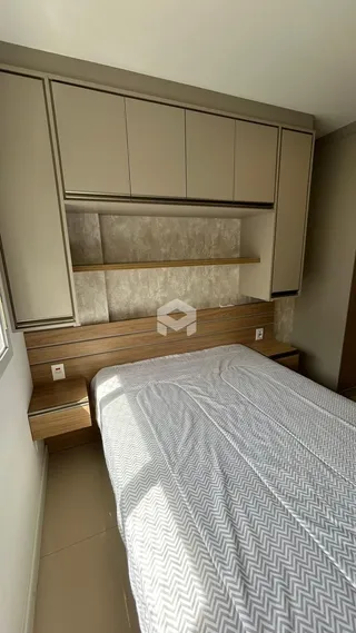 Foto de um quarto com cabeceira de madeira e armários embutidos.