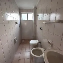 Corredor interno com paredes brancas e piso de cerâmica.