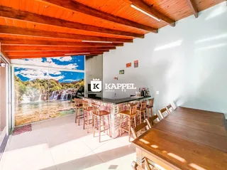 Vista de uma sala de jantar com grande abertura para uma paisagem de cachoeira.