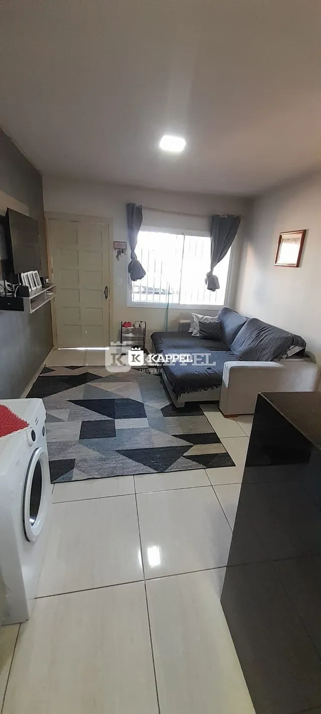 Sala de estar com sofá e piso claro.