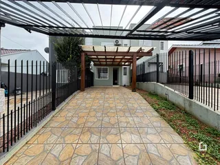 Vista de um pátio externo com piso de cerâmica e cerca de ferro.