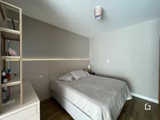 Quarto com cama e estante de madeira no interior da residência.