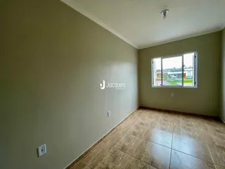 Vista interna de uma sala com piso de cerâmica e parede clara.