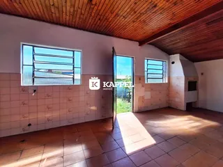 Sala com piso de cerâmica e teto de madeira, com acesso a uma área externa.