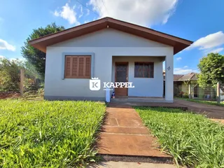 Fachada de uma casa branca com telhado inclinado em Lajeado, Brasil.