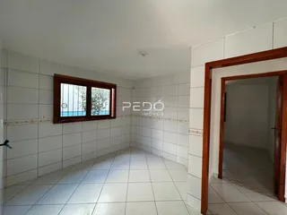 Vista de um corredor interno com paredes brancas e piso de cerâmica.