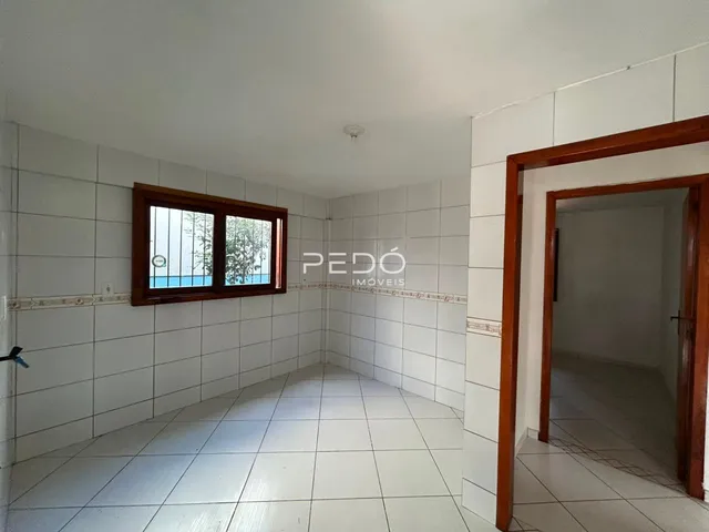 Vista de um corredor interno com paredes brancas e piso de cerâmica.