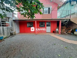 Fachada de uma casa vermelha com área coberta em Lajeado, Brasil.