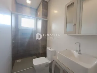 Foto de um banheiro com box de vidro e louças sanitárias.
