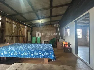 Quarto com piso de madeira e teto de madeira em imóvel em Lajeado.