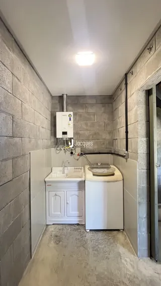 Foto de um banheiro com revestimento de azulejo cinza e bancada branca.
