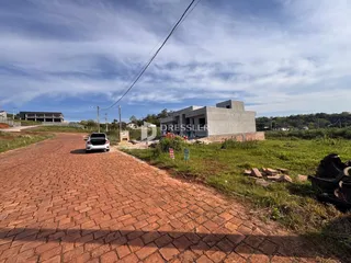 Vista da fachada de uma residência em construção em Lajeado, Brasil, ao lado de uma estrada de tijolos.