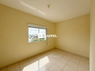 Uma sala interna com piso de cerâmica e uma janela que oferece uma vista da cidade.