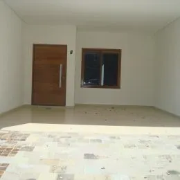 Foto de um corredor interno com porta de madeira em uma residência.