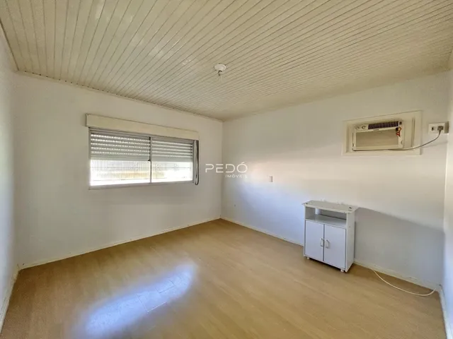 Esta é uma foto de uma sala interna com piso de madeira clara e teto de painéis.