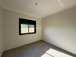 Interior de uma sala com parede lisa e piso de cerâmica.