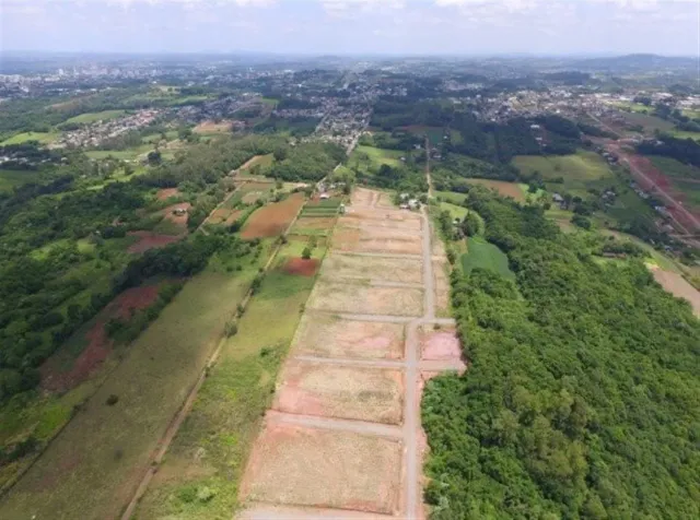 Vista aérea de um terreno rural com campos e vegetação densa.
