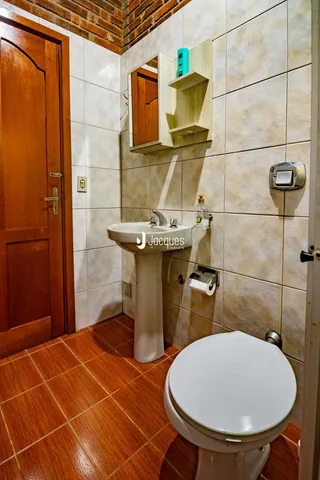 Foto de um banheiro com piso de cerâmica e paredes de azulejo.
