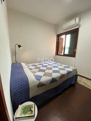 Quarto com cama e janela em ambiente interno.