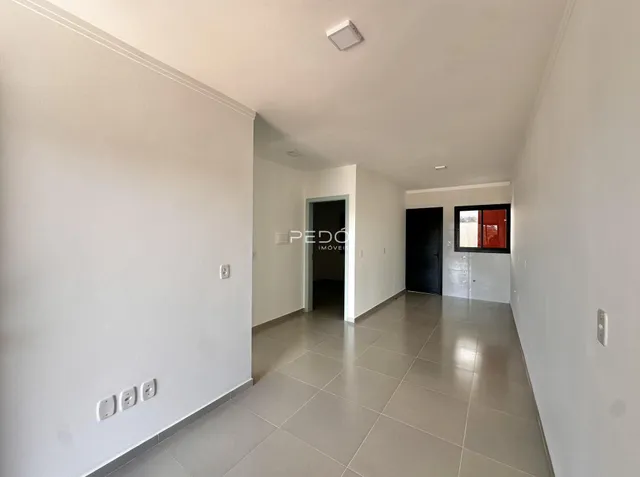 Corredor interno de uma residência com piso de cerâmica claro.