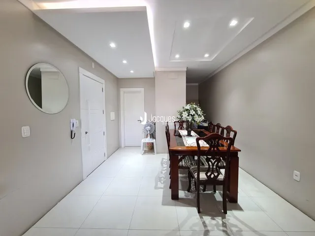 Hall de entrada com piso branco e paredes claras.
