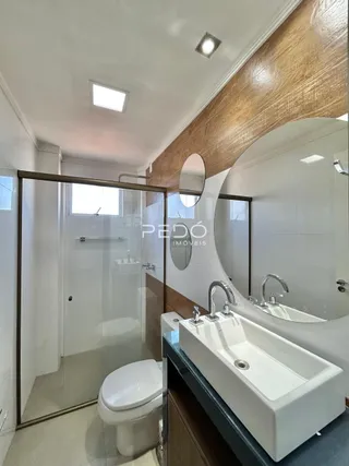 Foto de um banheiro moderno com box de vidro e pia de apoio.