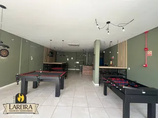 Imagem de uma área comum com mesas de jogos em um imóvel no Brasil.