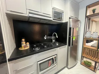 Cozinha moderna com armários brancos e eletrodomésticos de aço inoxidável.