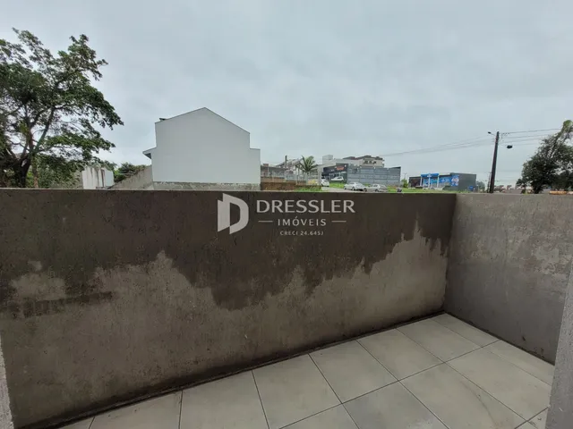 Parede externa de concreto com o logotipo de uma imobiliária.