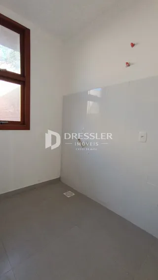 A sala apresenta paredes brancas e um piso claro.