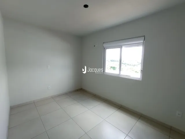 A sala de estar é uma área ampla com piso de cerâmica clara.