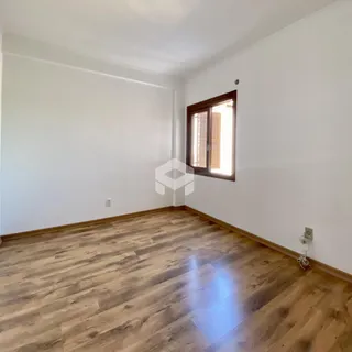 Sala de estar com piso de madeira clara e paredes brancas.
