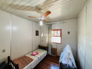 Quarto com cama e piso de madeira.