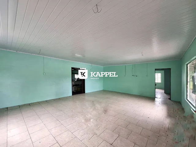 Foto de um ambiente interno amplo com paredes verde-água e piso de cerâmica.