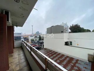 Vista de uma varanda com piso de cerâmica e grade de segurança em Lajeado.