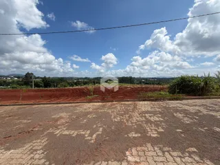 Vista da propriedade com campo aberto e vegetação ao fundo.