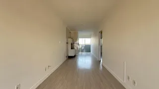 Corredor interno de uma residência com piso de madeira clara.